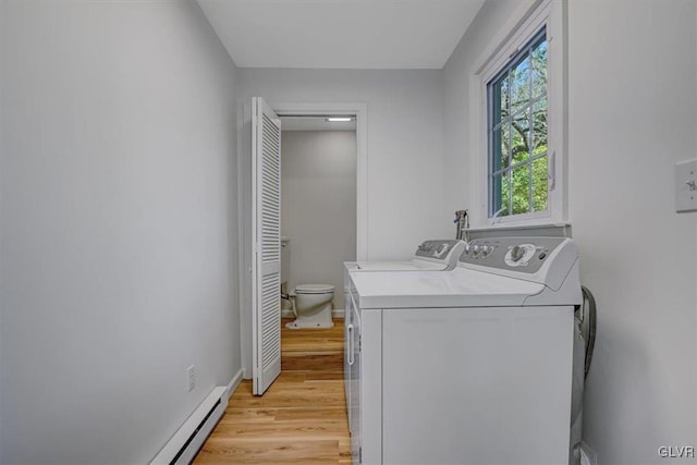 washroom featuring washer and dryer, light wood-type flooring, and a baseboard radiator