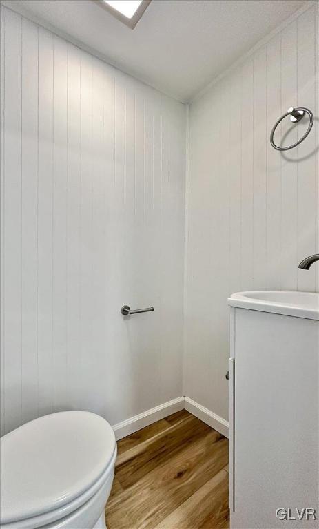 bathroom with hardwood / wood-style flooring, vanity, and toilet