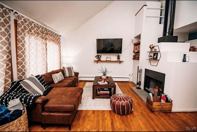 living room featuring a baseboard radiator, hardwood / wood-style flooring, and high vaulted ceiling