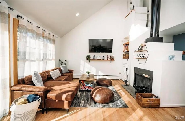 living room featuring hardwood / wood-style flooring, a baseboard radiator, and vaulted ceiling