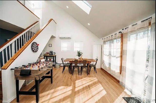 dining room featuring light hardwood / wood-style flooring, an AC wall unit, high vaulted ceiling, and a wealth of natural light