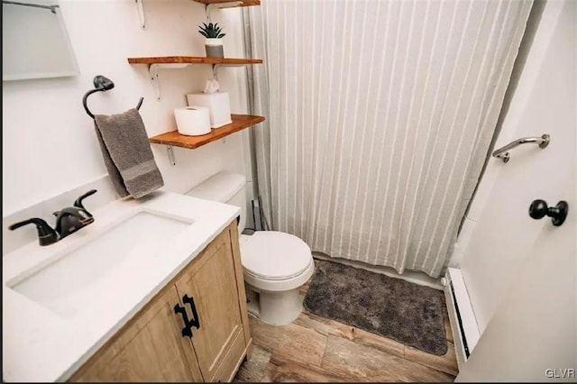 bathroom with vanity, curtained shower, toilet, and a baseboard radiator