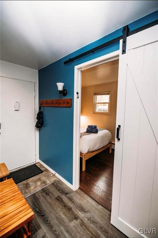 interior space featuring dark wood-type flooring and a barn door