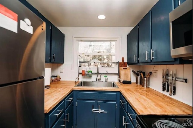 kitchen featuring blue cabinets, stainless steel appliances, and sink