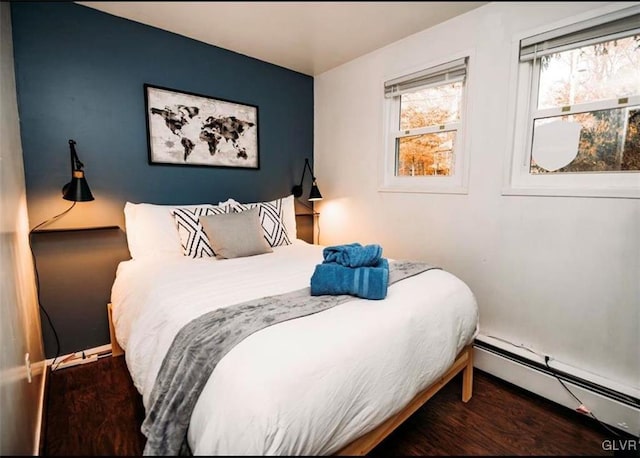 bedroom with a baseboard radiator and dark hardwood / wood-style flooring