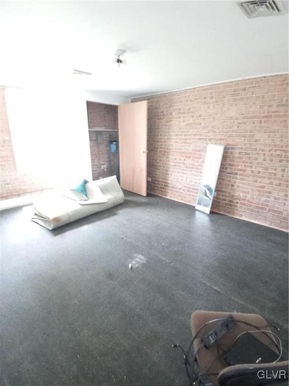 unfurnished living room with brick wall