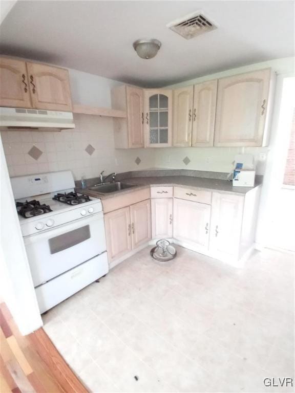 kitchen featuring white range with gas stovetop, sink, and light brown cabinets