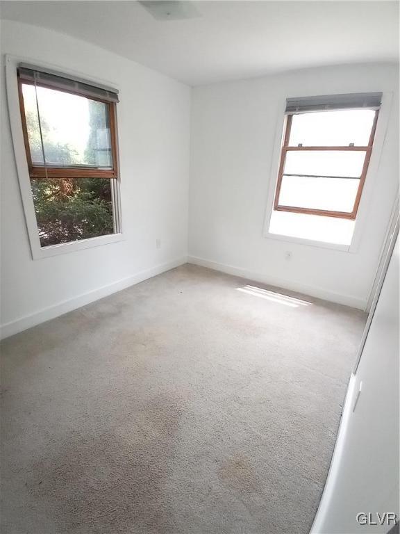 spare room featuring baseboards and carpet floors