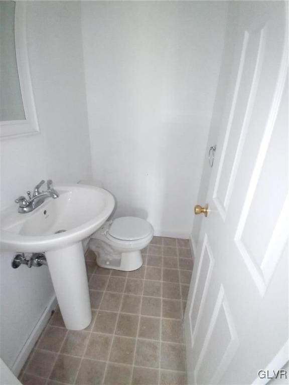 half bath with tile patterned floors and toilet