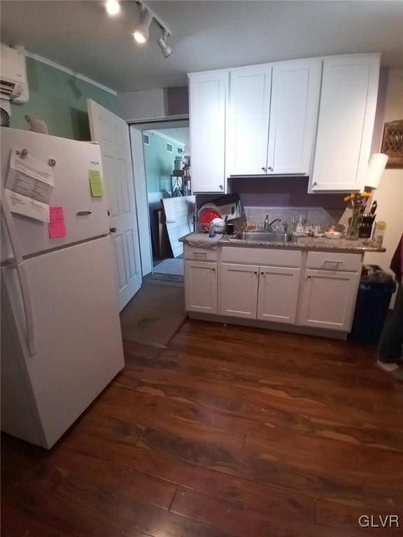 kitchen with dark wood-type flooring, white cabinets, and white refrigerator