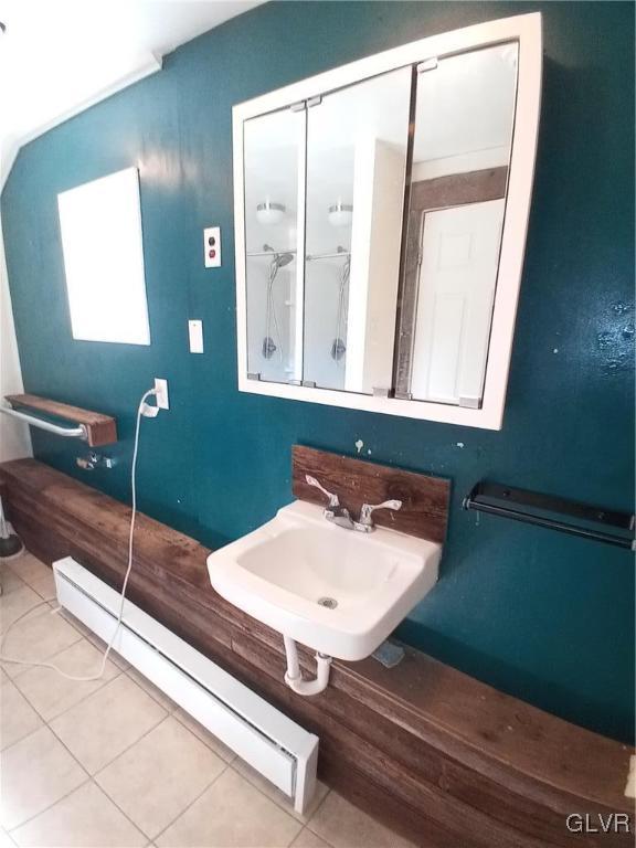 bathroom featuring tile patterned floors, a baseboard radiator, walk in shower, and a sink