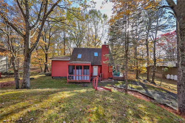 back of property with a yard and a sunroom