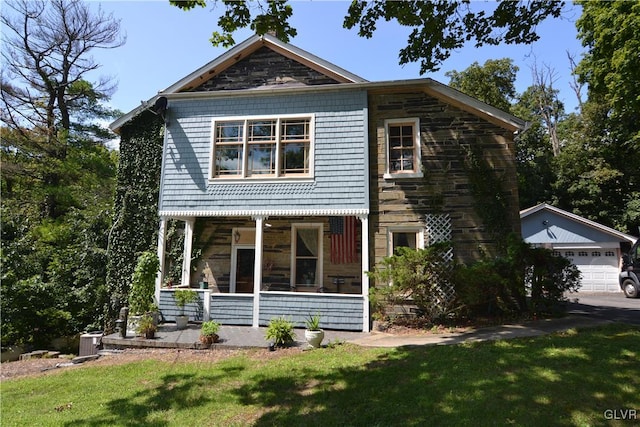 view of front of home featuring a garage, covered porch, and a front lawn