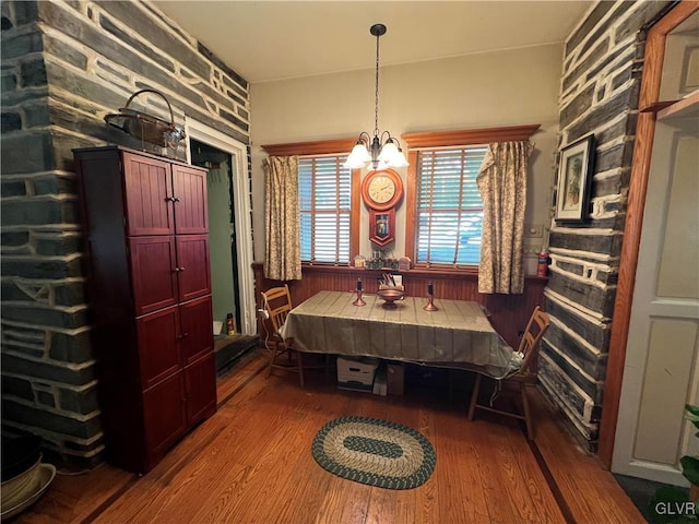 dining area featuring wood-type flooring and an inviting chandelier