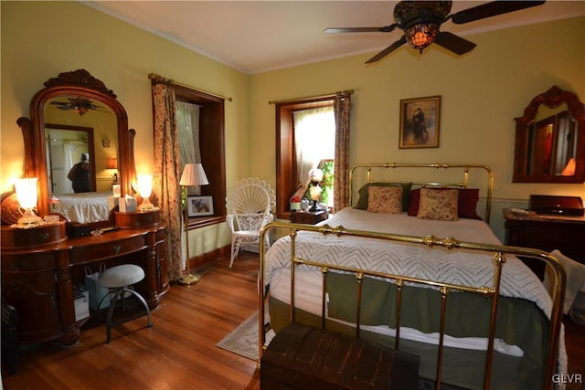 bedroom with hardwood / wood-style floors, ceiling fan, and ornamental molding