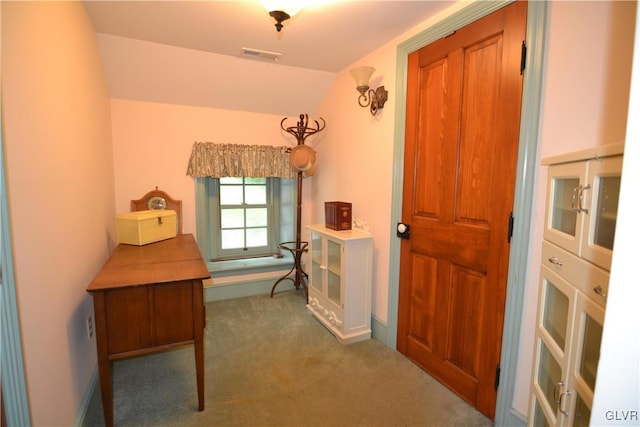 carpeted home office featuring visible vents, baseboards, and vaulted ceiling