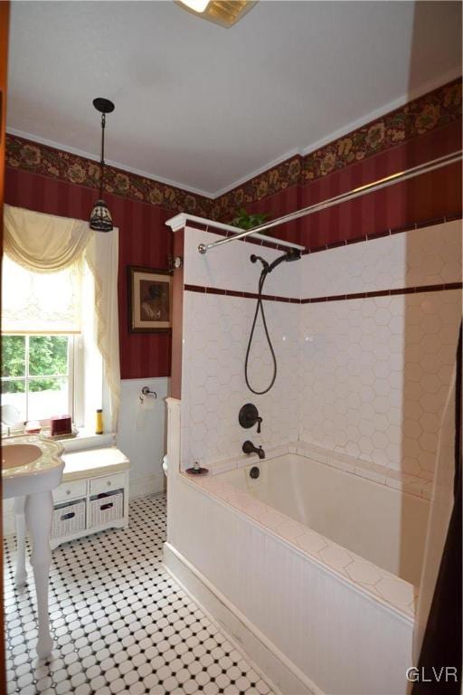 bathroom with toilet, tiled shower / bath, and ornamental molding