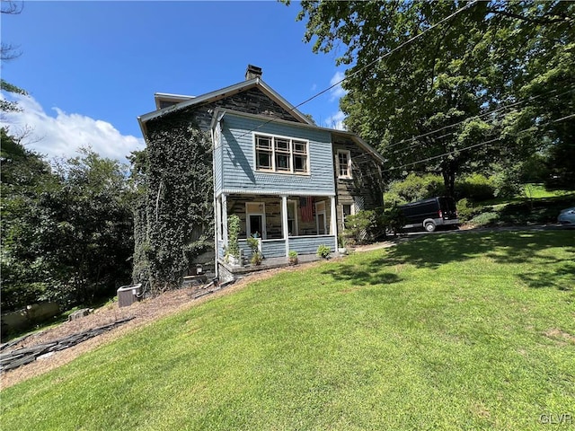 exterior space with covered porch and a yard