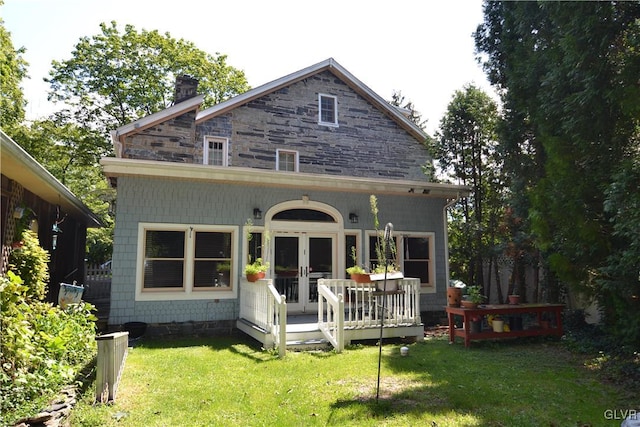 rear view of property featuring a yard, french doors, and a chimney