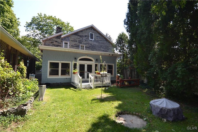 back of property featuring french doors, a yard, and a wooden deck