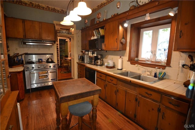 kitchen featuring sink, tasteful backsplash, tile countertops, pendant lighting, and black appliances