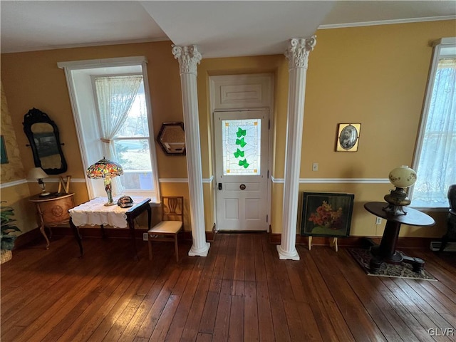 living area featuring hardwood / wood-style floors, crown molding, decorative columns, and baseboards