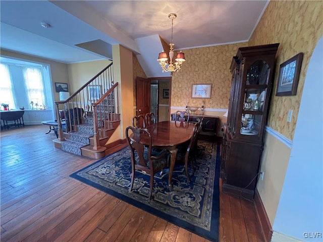 dining area featuring wallpapered walls, stairs, an inviting chandelier, and wood-type flooring