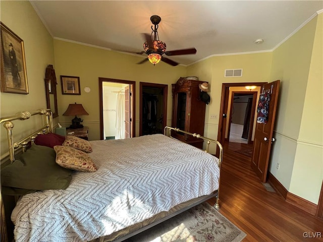 bedroom featuring wood finished floors, visible vents, baseboards, ceiling fan, and crown molding