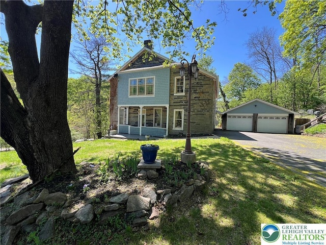 1321 Main St, Chapman, PA 18014 - shingle-style home featuring a detached garage, stone siding, an outbuilding, a front yard, and a sunroom
