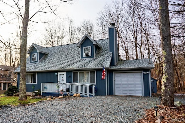 new england style home with covered porch and a garage