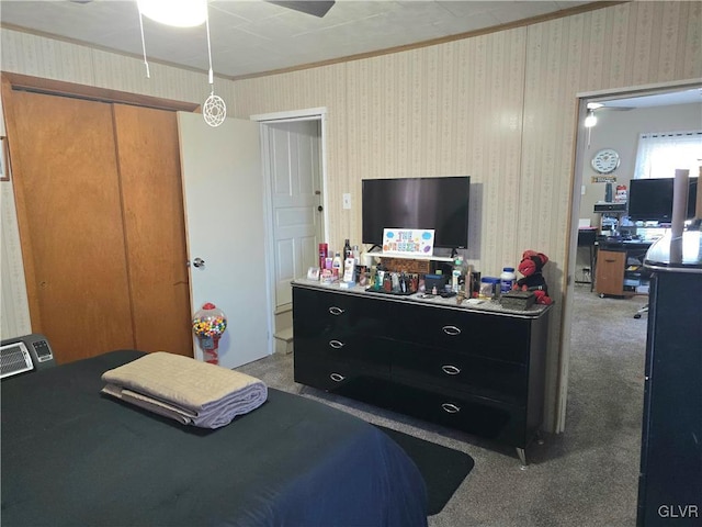 carpeted bedroom with ornamental molding and a closet