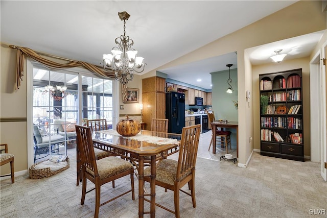 dining space featuring light carpet, a chandelier, and vaulted ceiling