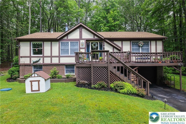 137 Outer Dr, Coolbaugh Twp, PA 18347 - view of front facade featuring stucco siding, a wooden deck, a front yard, and driveway