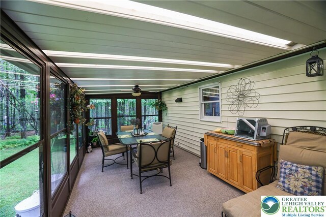 137 Outer Dr, Coolbaugh Twp, PA 18347 - sunroom / solarium featuring outdoor dining area, carpet floors, ceiling fan, and wooden walls