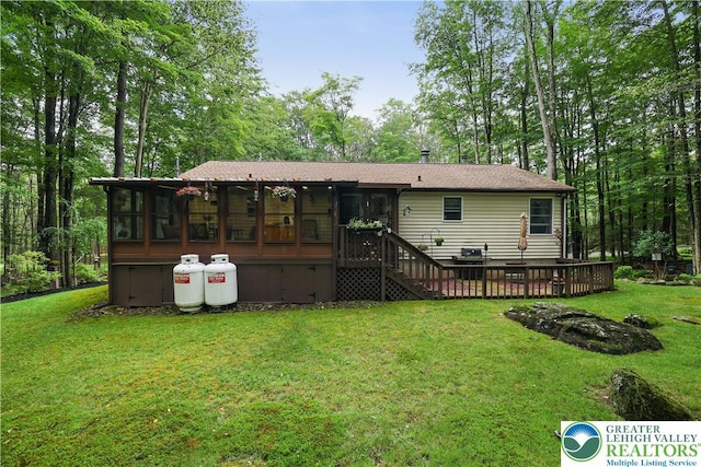 137 Outer Dr, Coolbaugh Twp, PA 18347 - rear view of house featuring a sunroom, a yard, and a wooden deck