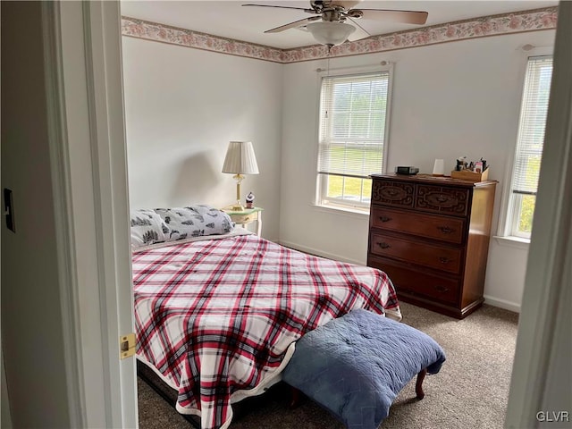 bedroom featuring light carpet, multiple windows, and ceiling fan