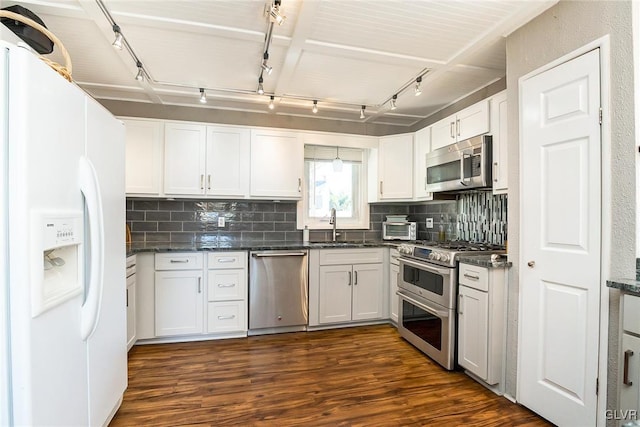 kitchen featuring dark hardwood / wood-style floors, decorative backsplash, white cabinetry, and stainless steel appliances