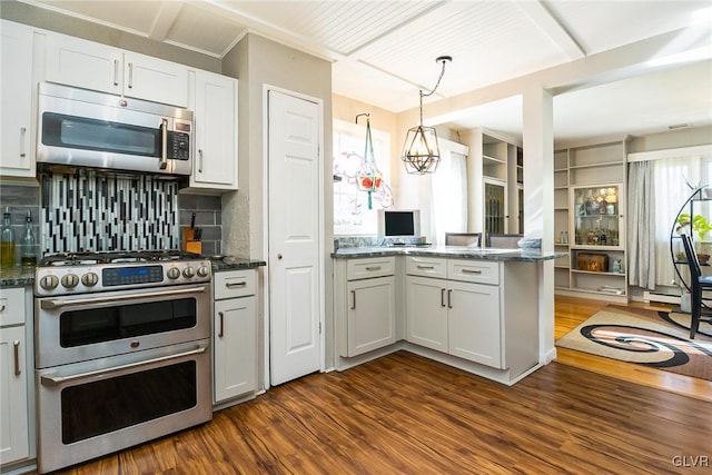 kitchen with backsplash, dark wood-type flooring, white cabinetry, kitchen peninsula, and stainless steel appliances