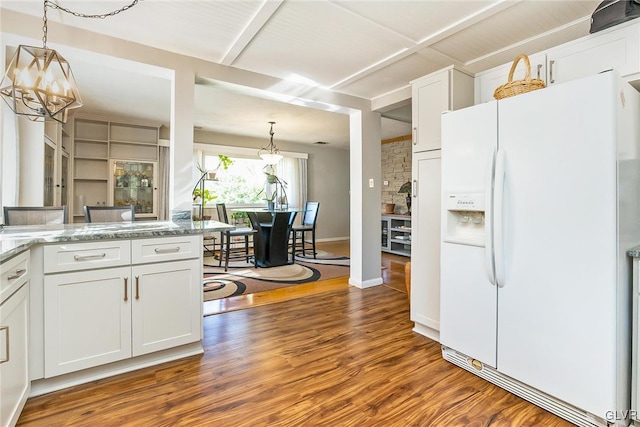 kitchen featuring white cabinetry, hanging light fixtures, dark wood-type flooring, and white refrigerator with ice dispenser