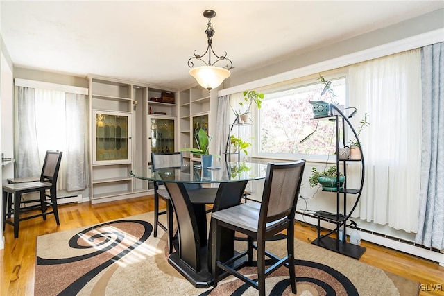 dining room with light hardwood / wood-style flooring and a baseboard heating unit