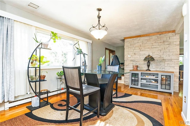 dining space featuring light hardwood / wood-style flooring and baseboard heating