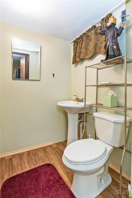 bathroom with hardwood / wood-style flooring and toilet