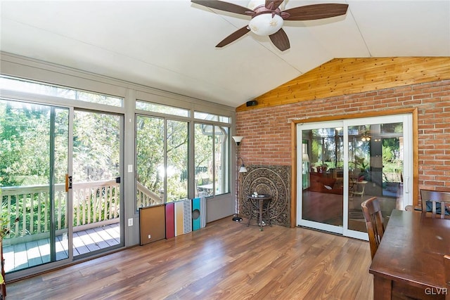 unfurnished sunroom with ceiling fan, a healthy amount of sunlight, and vaulted ceiling