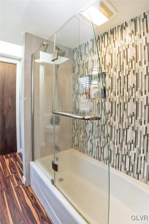 bathroom with shower / bath combination with glass door and wood-type flooring