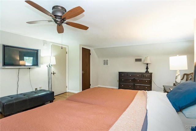 bedroom with ceiling fan, light hardwood / wood-style flooring, and vaulted ceiling