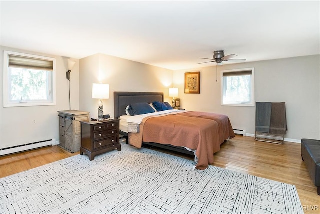 bedroom with ceiling fan, light hardwood / wood-style floors, and a baseboard radiator