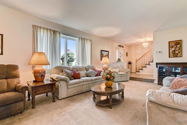 living room featuring carpet flooring and an inviting chandelier