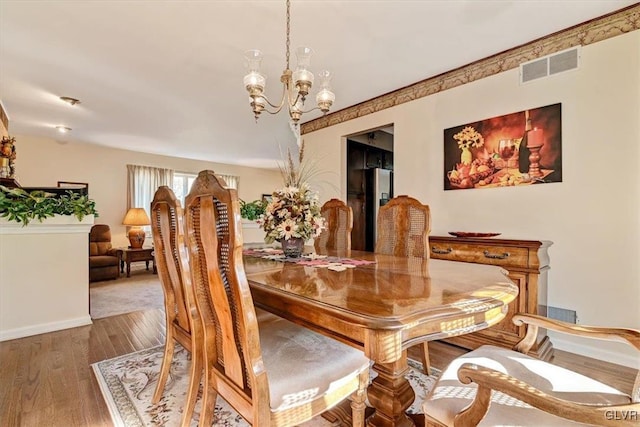 dining space with an inviting chandelier and hardwood / wood-style flooring