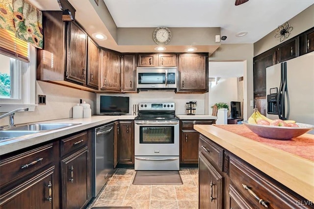 kitchen featuring sink, appliances with stainless steel finishes, and dark brown cabinets