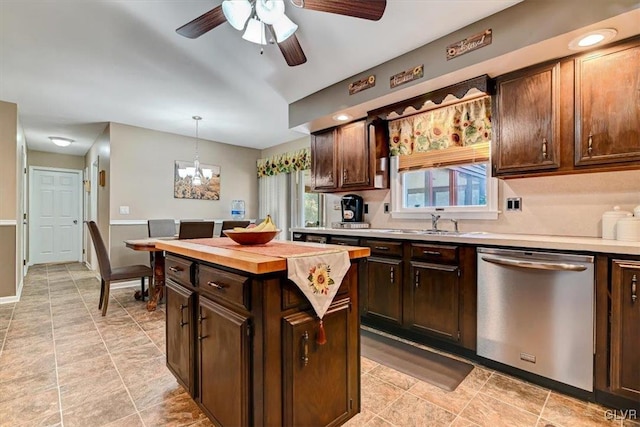 kitchen with dishwasher, a kitchen island, dark brown cabinets, pendant lighting, and ceiling fan with notable chandelier